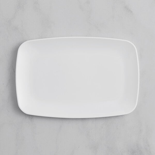 A white rectangular plastic platter with a silver band on a marble surface.