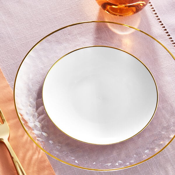 A white Visions plastic plate with a gold rim on a table.