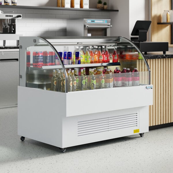 An Avantco white horizontal air curtain merchandiser with drinks in it.