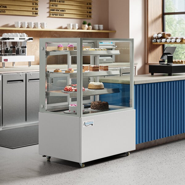 A white Avantco refrigerated bakery display case filled with cakes.