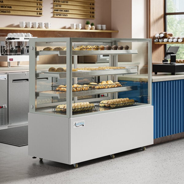 An Avantco white square dry bakery display case with food on shelves.