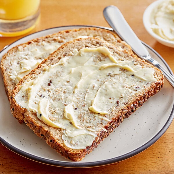 Two slices of bread with Miyoko's Cultured Oat Milk Vegan Butter on them.