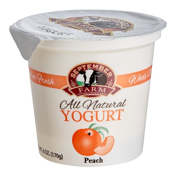 A white September Farm peach yogurt container with a plastic lid.