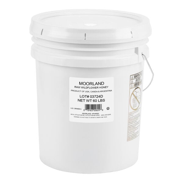 A white bucket with a label reading "Dutch Gold Raw Wildflower Honey"