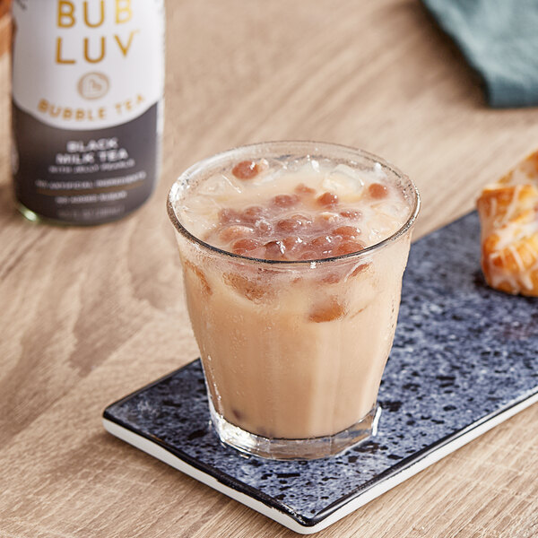 A glass of Bubluv black milk tea with ice and brown liquid with jelly pearls.