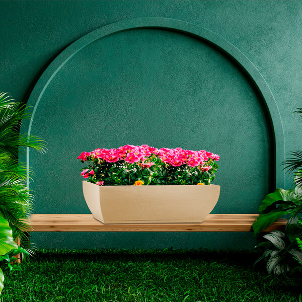 A rectangular beige Floridis Amsterdam planter box with flowers on a bench.