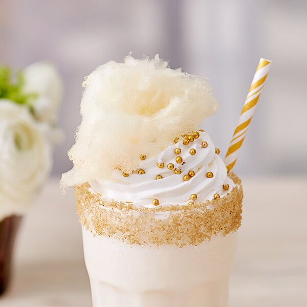 A close up of a milkshake with a straw and white and gold frosting made with Great Western Pina Colada Cotton Candy Floss Sugar.