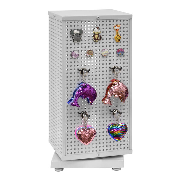 A white steel 4-sided pegboard countertop retail spinner display with various charms on it.