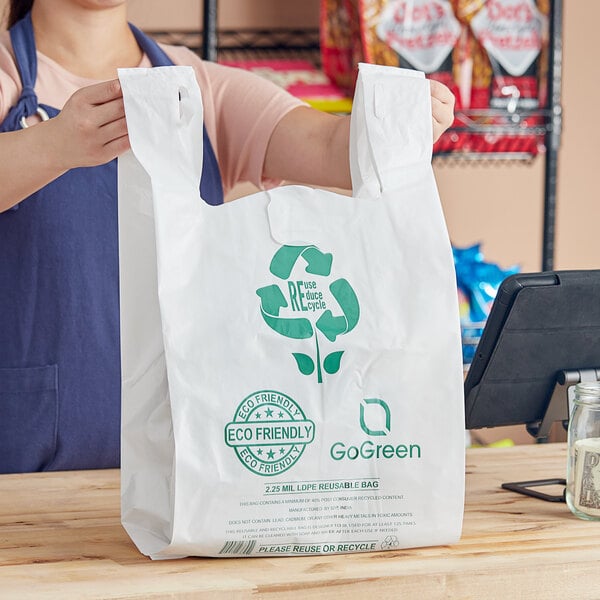 A woman holding a white Choice plastic t-shirt bag with green text.