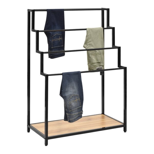A black metal 4-tier ladder display rack with jeans on it.