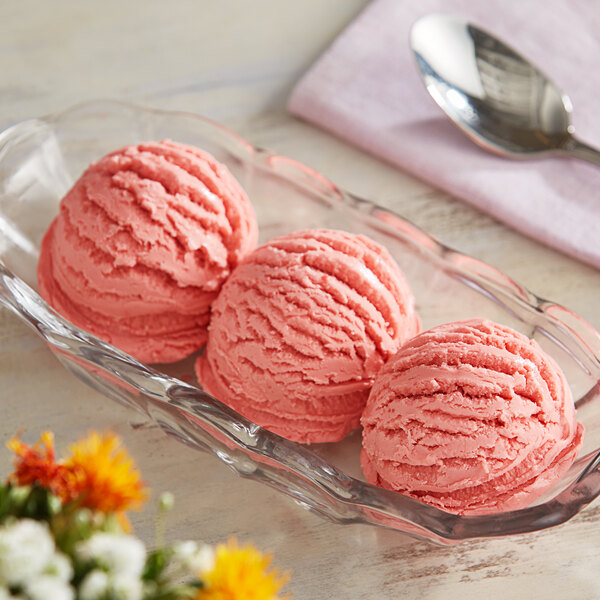 A bowl of pink ice cream with a spoon.