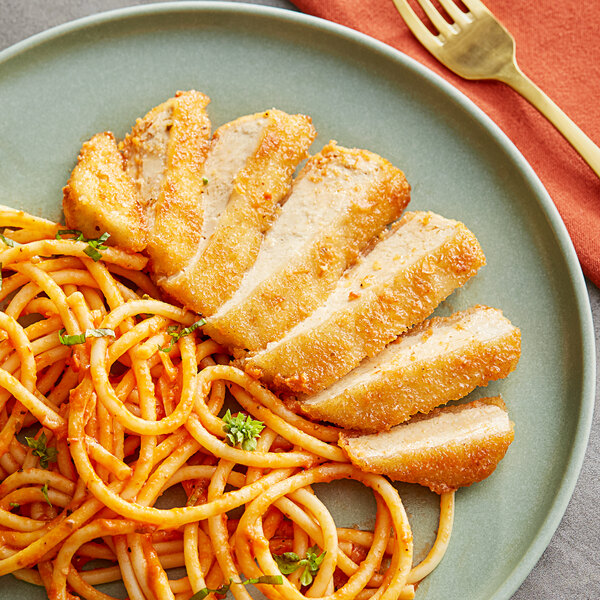 A plate of Gardein plant-based breaded chick'n breast on a plate with spaghetti and a fork.