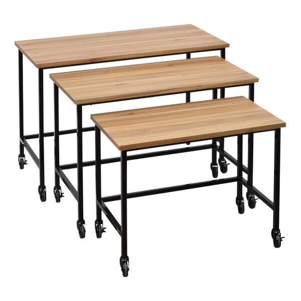 A 3-piece olive wood nesting display table set with black steel legs and wheels.