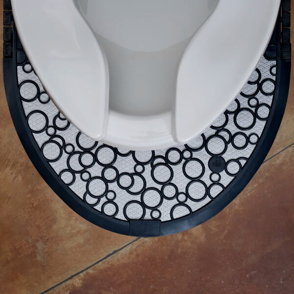 A black and white disposable toilet floor mat with a circular pattern placed around the base of a toilet.