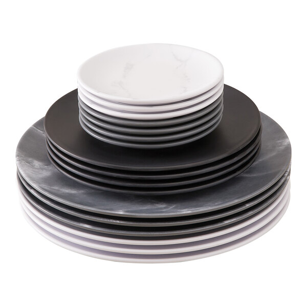 A stack of American Metalcraft Matte Black Melamine Coupe Plates on a white surface.