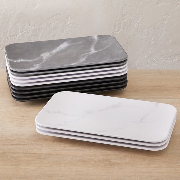 A stack of rectangular white and black American Metalcraft Mix & Matte rectangular platters.