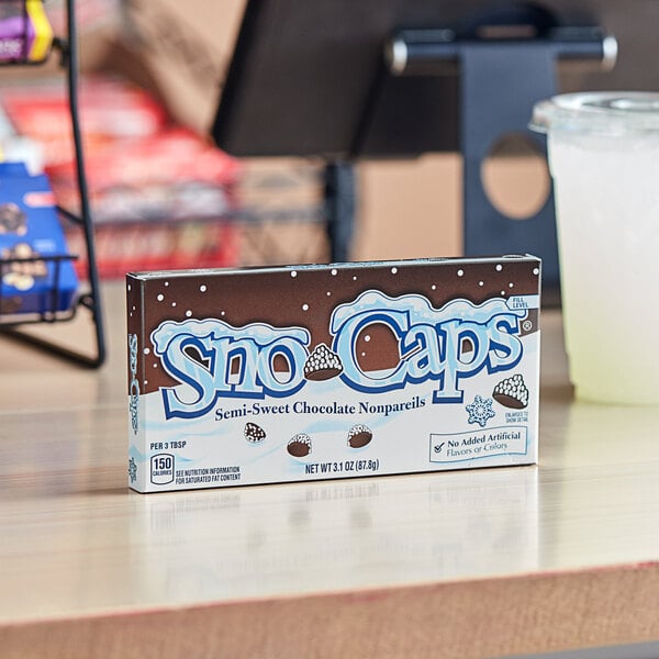 A blue SNO CAPS Chocolate box on a table.