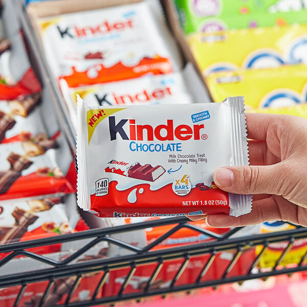 A person holding a package of KINDER chocolate bars.