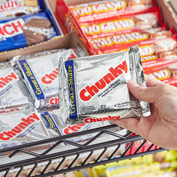 A hand holding a package of CHUNKY® Giant Chocolate bars.