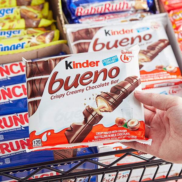 A hand holding a package of KINDER Bueno King Size Hazelnut Milk Chocolate Bars.