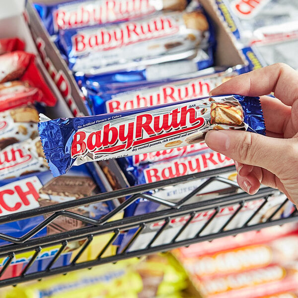 A person holding a box of BABY RUTH candy bars.