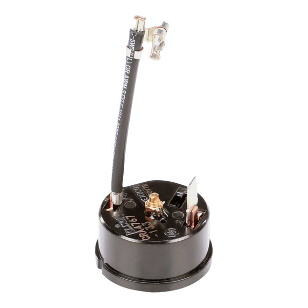 An Ice-O-Matic overload compressor with black and white wires and a metal rod.