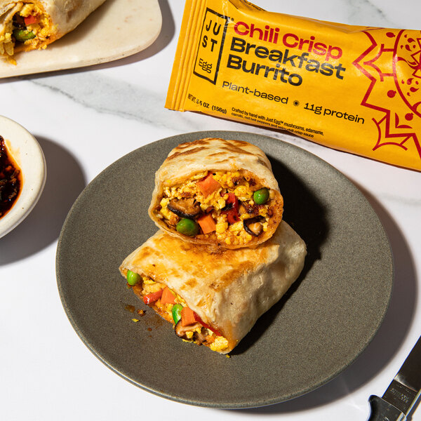 An Eat Just Egg breakfast burrito on a plate with vegetables.