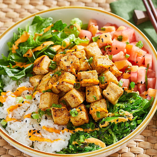 A bowl of rice and vegetables with close-up cubes of Nasoya Organic Baked Tofu.