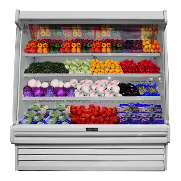 A white Howard McCray vertical open air curtain produce merchandiser with three shelves of fruits and vegetables.