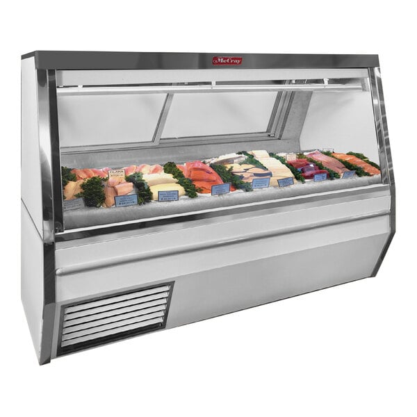 A white Howard McCray refrigerated meat and poultry case with fish and poultry on display.