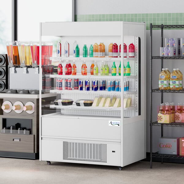 An Avantco white vertical open air merchandiser with shelves holding bottles of liquid.