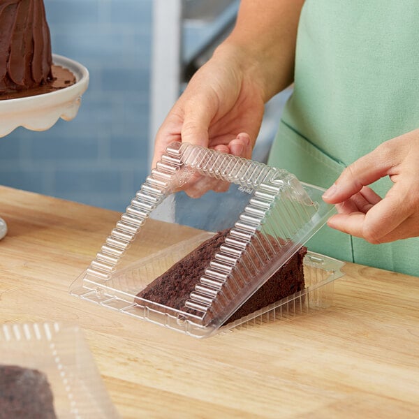 A woman using a Polar Pak plastic container to put a piece of cake in it.