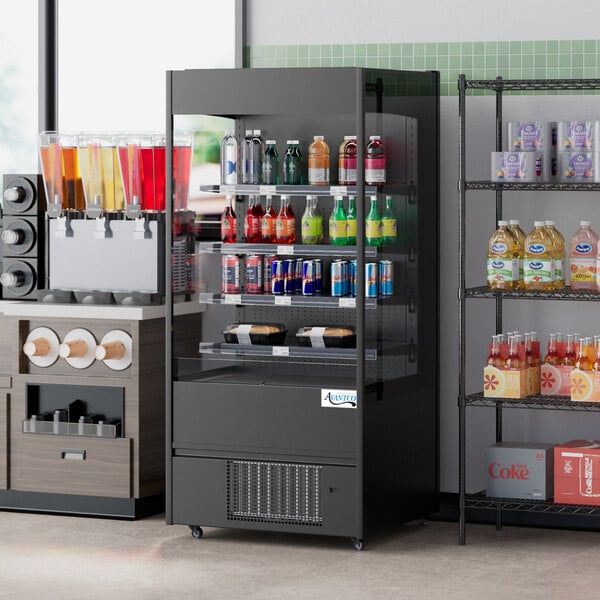 An Avantco black vertical open air merchandiser with drinks and snacks on shelves.