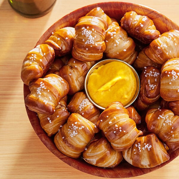 A bowl of Ditsch soft pretzel bites with a salt packet on the table.
