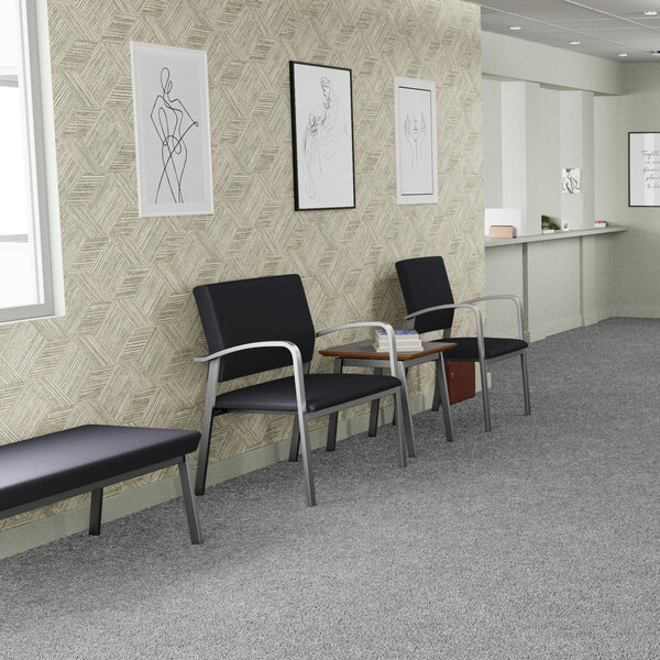 A black vinyl guest arm chair with silver powder-coated steel legs, designed for waiting areas.