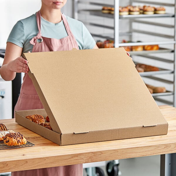 A woman opening a Choice Kraft bakery box filled with pastries.