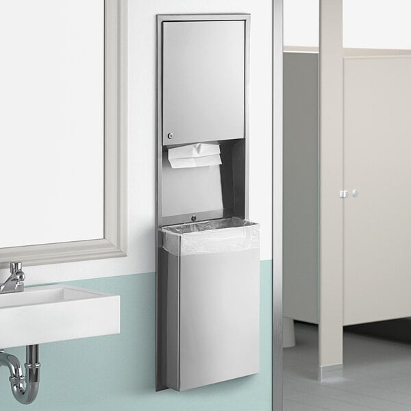 A Lavex stainless steel paper towel dispenser with a waste receptacle above a white sink.
