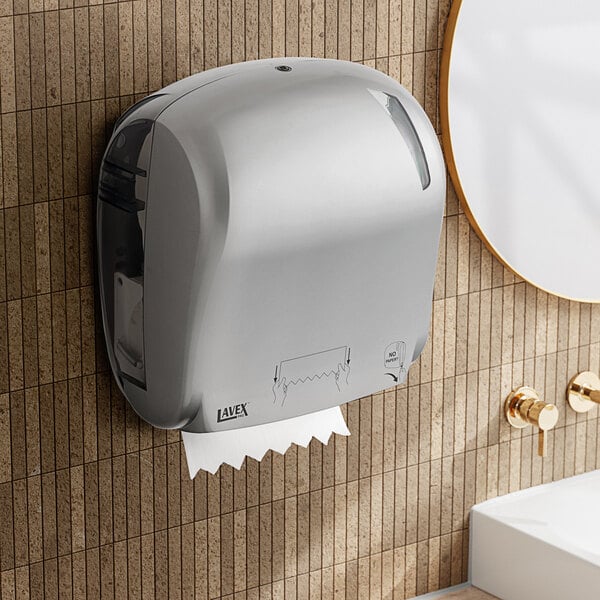 A Lavex Pro titanium paper towel dispenser on a wall above a sink.