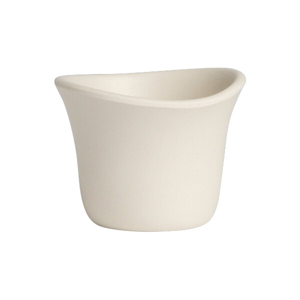 A white sauce dish with a curved edge.