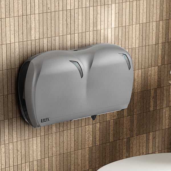 A Lavex Pro titanium double-roll jumbo toilet tissue dispenser on a wall.