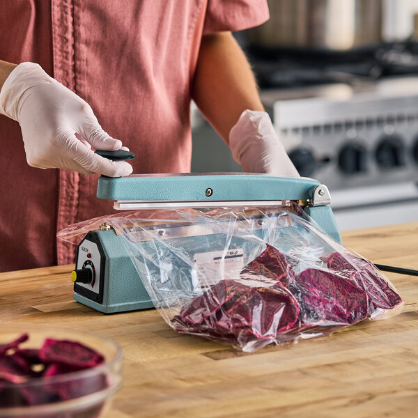 An 8-inch impulse bag sealer with a timer being used to seal a plastic bag containing food.
