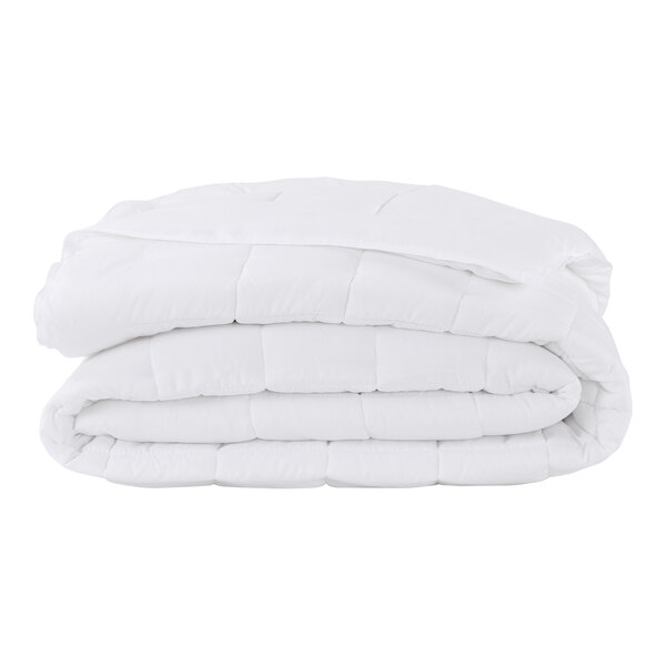 A stack of Berkshire Hospitality white comforters.