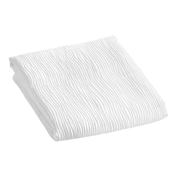 A white Berkshire Hospitality Ripple Weave Puff Jacquard top sheet folded on a white surface.