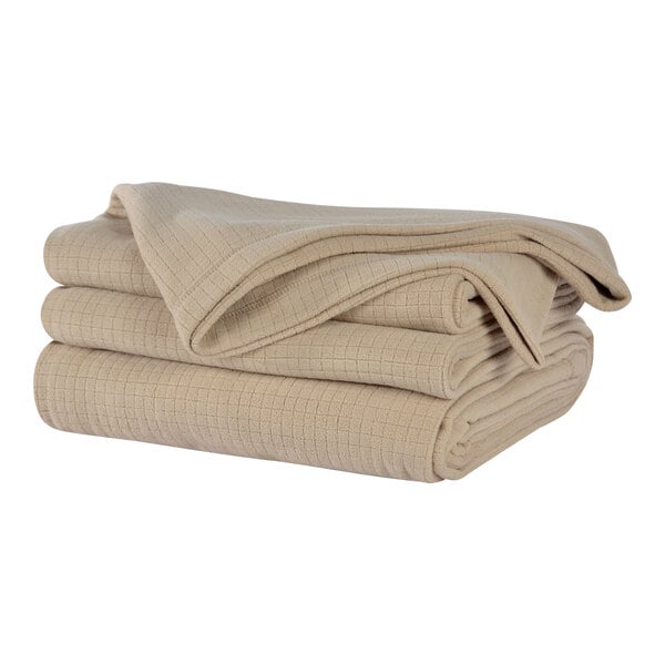A stack of beige Berkshire Hospitality fleece blankets.