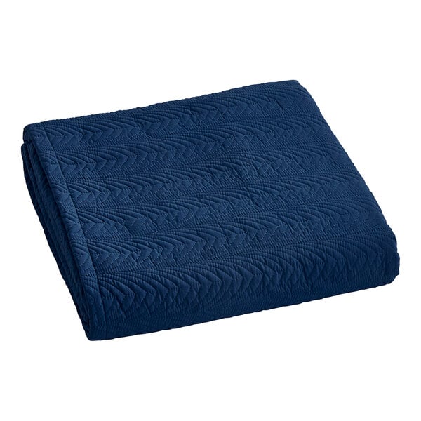 A navy blue Berkshire Hospitality botanical leaf quilt throw-style bedspread.