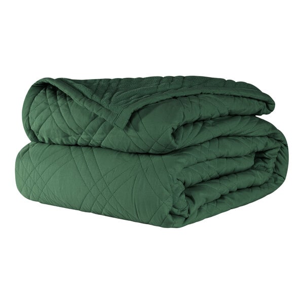 A stack of green Berkshire Hospitality bedspreads.