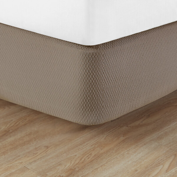 A bed with a Berkshire Hospitality Pecan Diamond Box Spring Cover on a mattress.