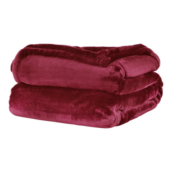 A stack of red Berkshire Hospitality VelvetLoft throw blankets.