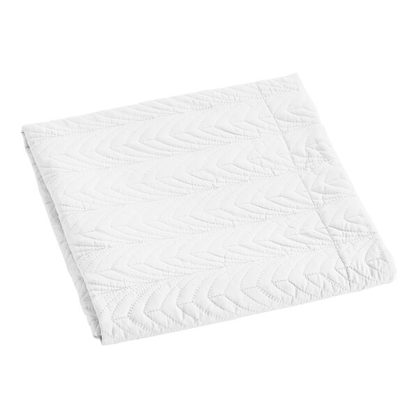 A white polyester quilted pillow sham with a botanical leaf design.