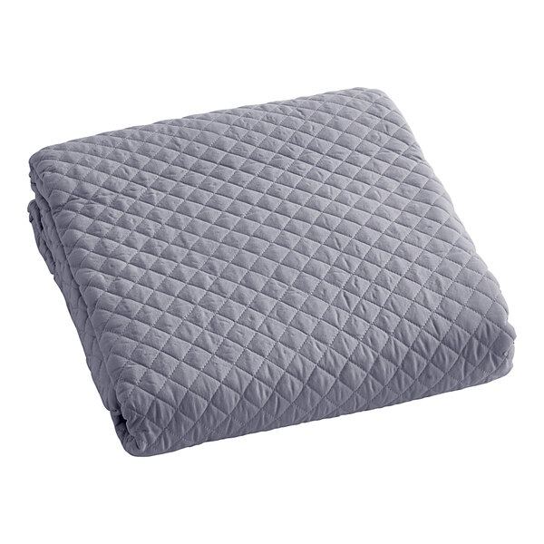 A grey quilted bedspread with a diamond pattern.